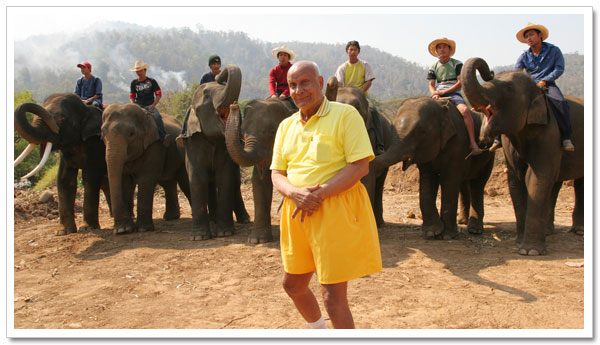 Sri Chinmoy stands before the elephants he has just lifted Sri Chinmoy stands before the elephants he has just lifted